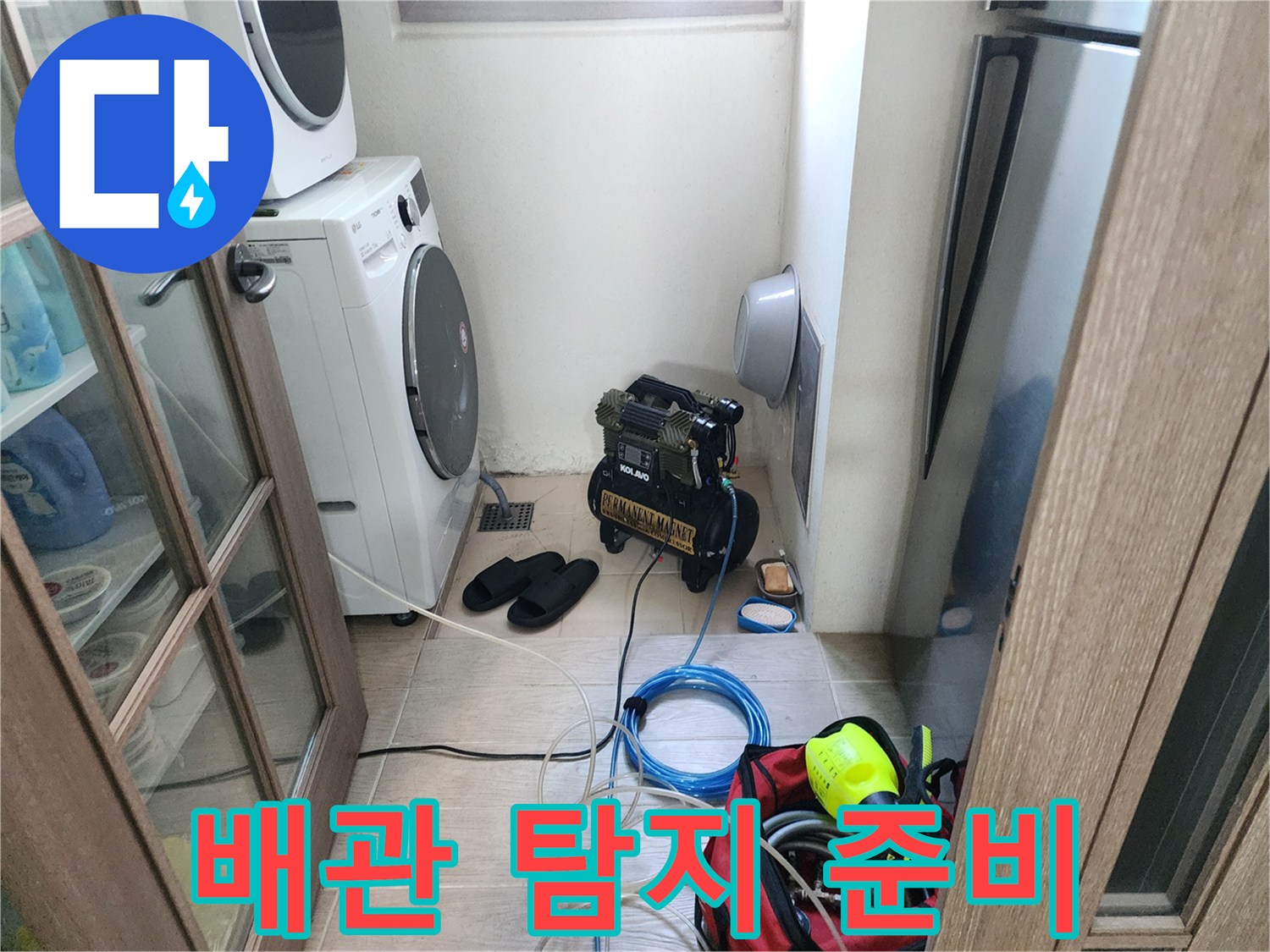 세탁실 바닥의 검은색 장비와 파란색 전선 릴 배치