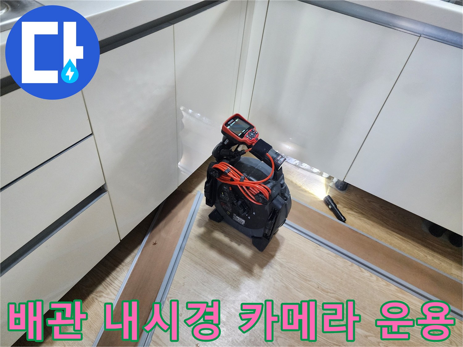싱크대 하단 배관의 결함을 찾기 위해 내시경 장비를 사용하여 내부를 확인하고 있습니다.