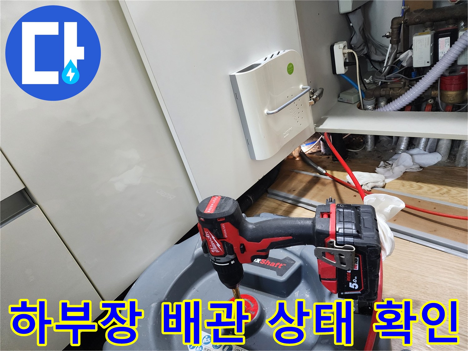 전동 공구를 활용하여 싱크대 하부 배관을 점검하는 엔지니어