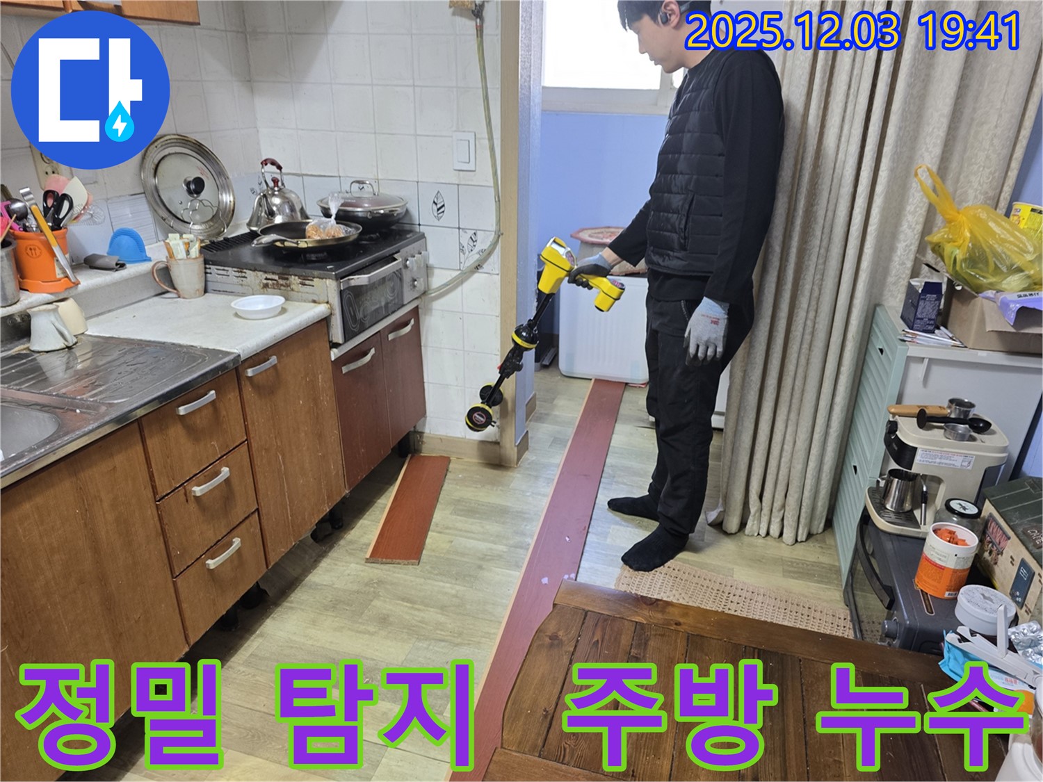 안양 프라자아파트 주방에서 누수탐지 전문가가 정밀 장비를 사용하여 누수 위치를 탐색하고 있습니다 - 정확한 진단과 신속한 해결