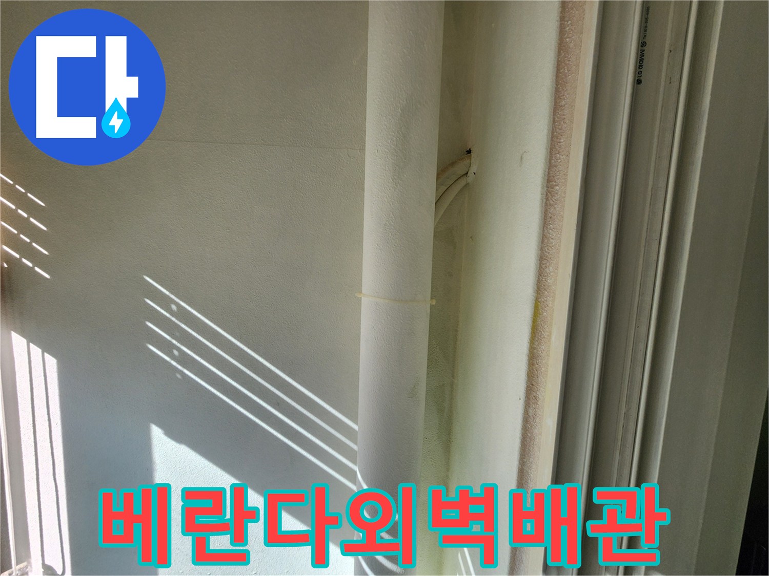 베란다 외벽에 설치된 하얀색 배관과 벽면 상태를 보여주는 사진입니다.