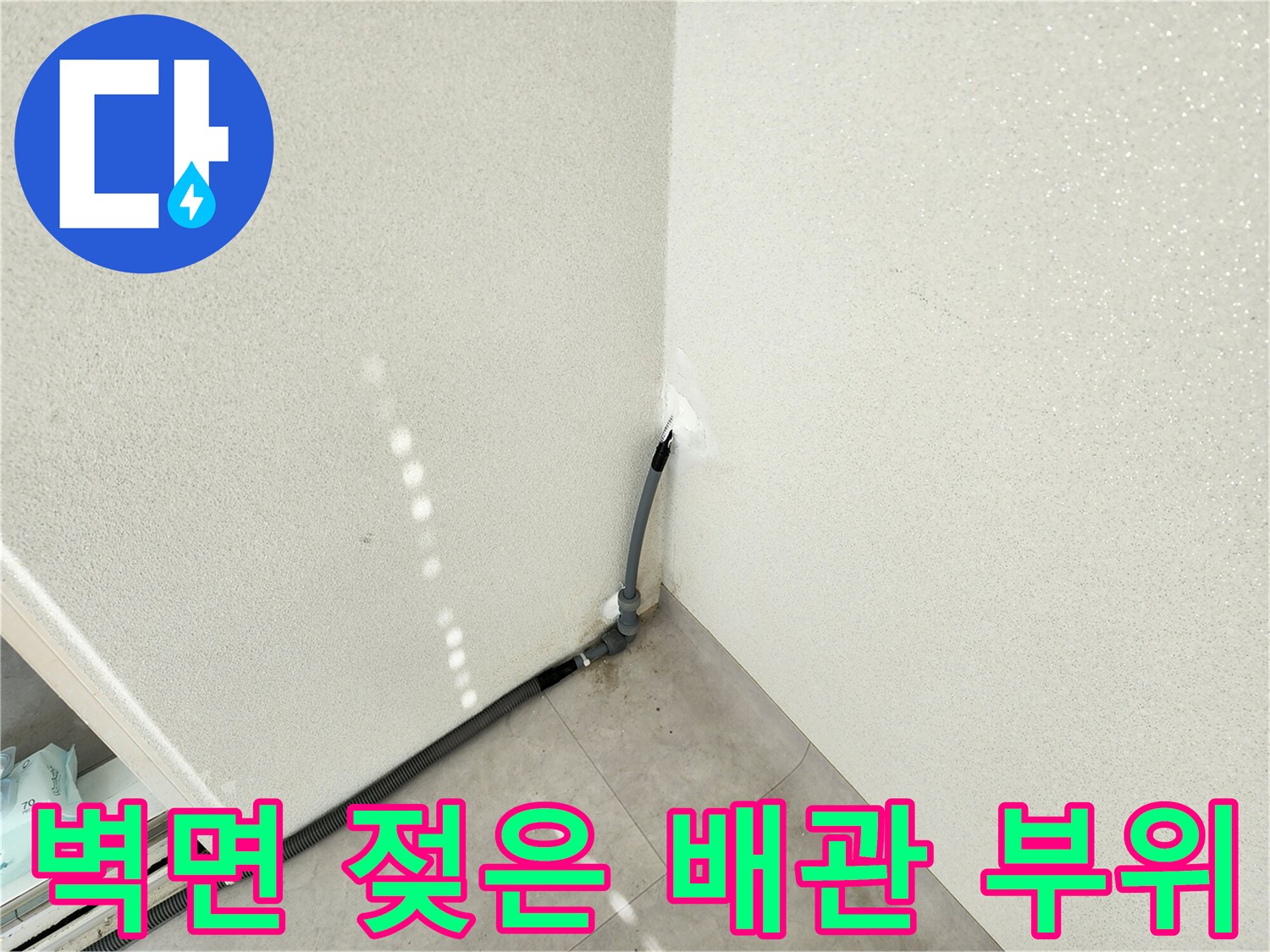 습기가 발견된 베란다 벽면과 회색 배관의 근접 사진입니다.