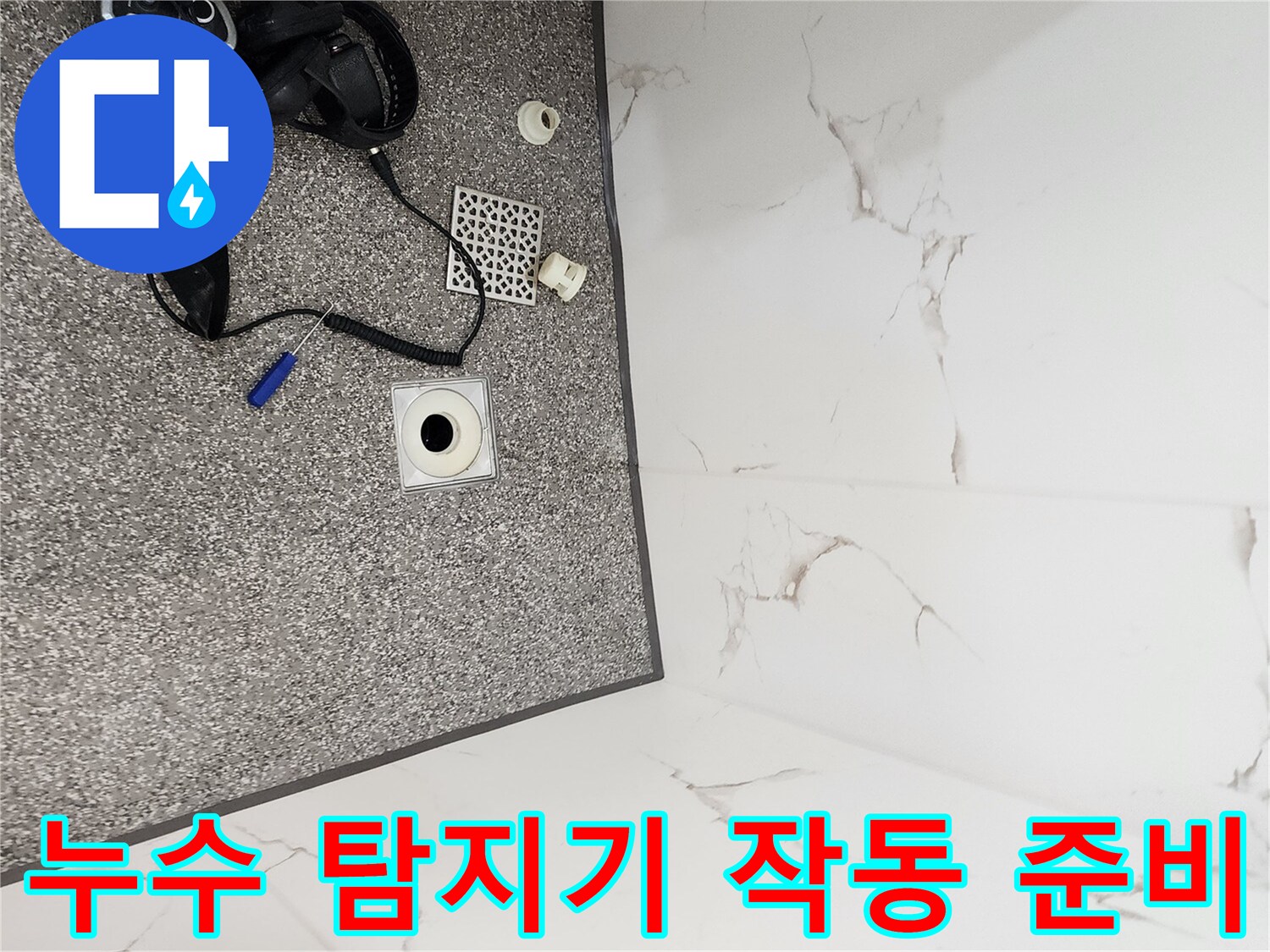바닥 타일 위에 놓인 가스식 누수 탐지기와 검사 장비들입니다.