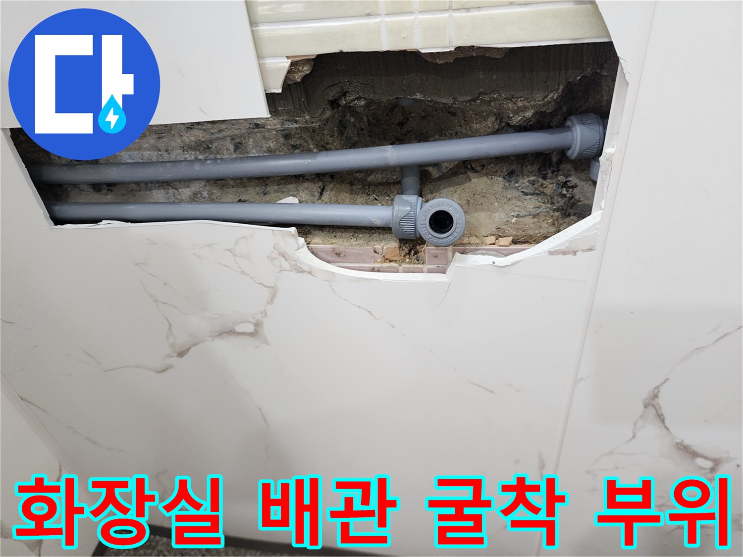 타일 아래 노출된 회색 수도 배관과 연결 소켓 상태