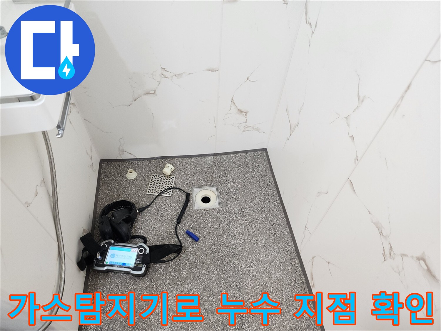 화장실 바닥에서 가스 탐지기를 사용하여 정밀하게 누수 부위를 찾는 모습입니다.