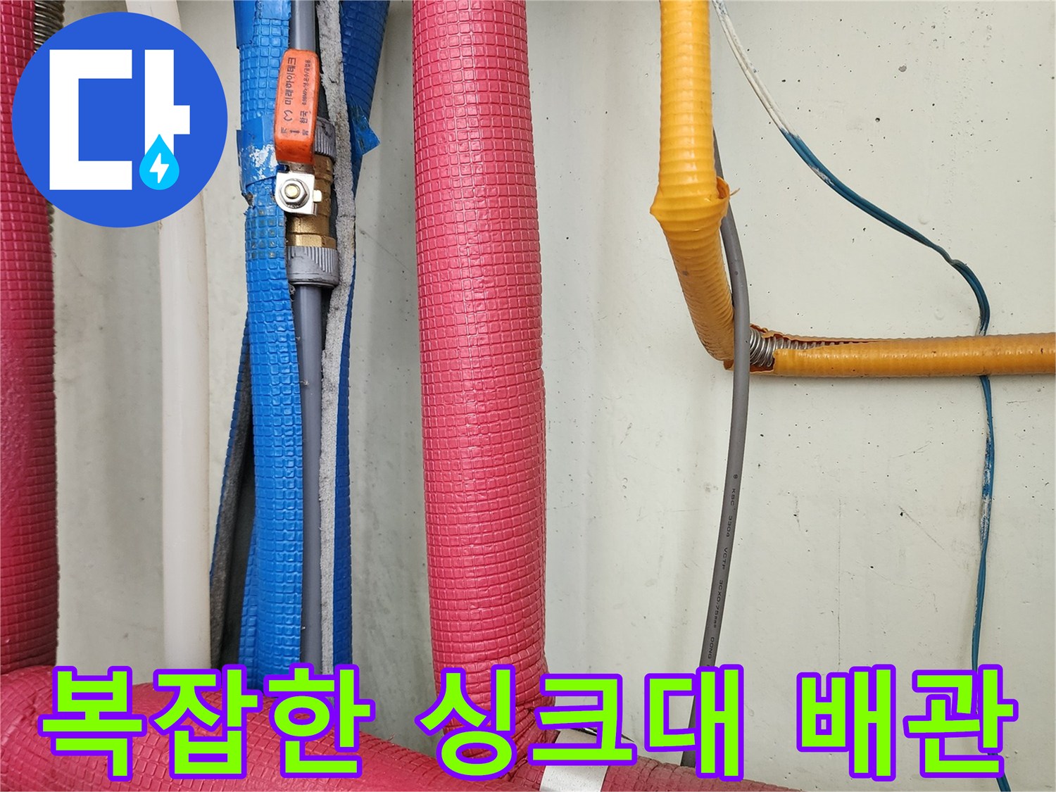 다양한 색상의 단열재로 마감된 싱크대 하부 배관 구조