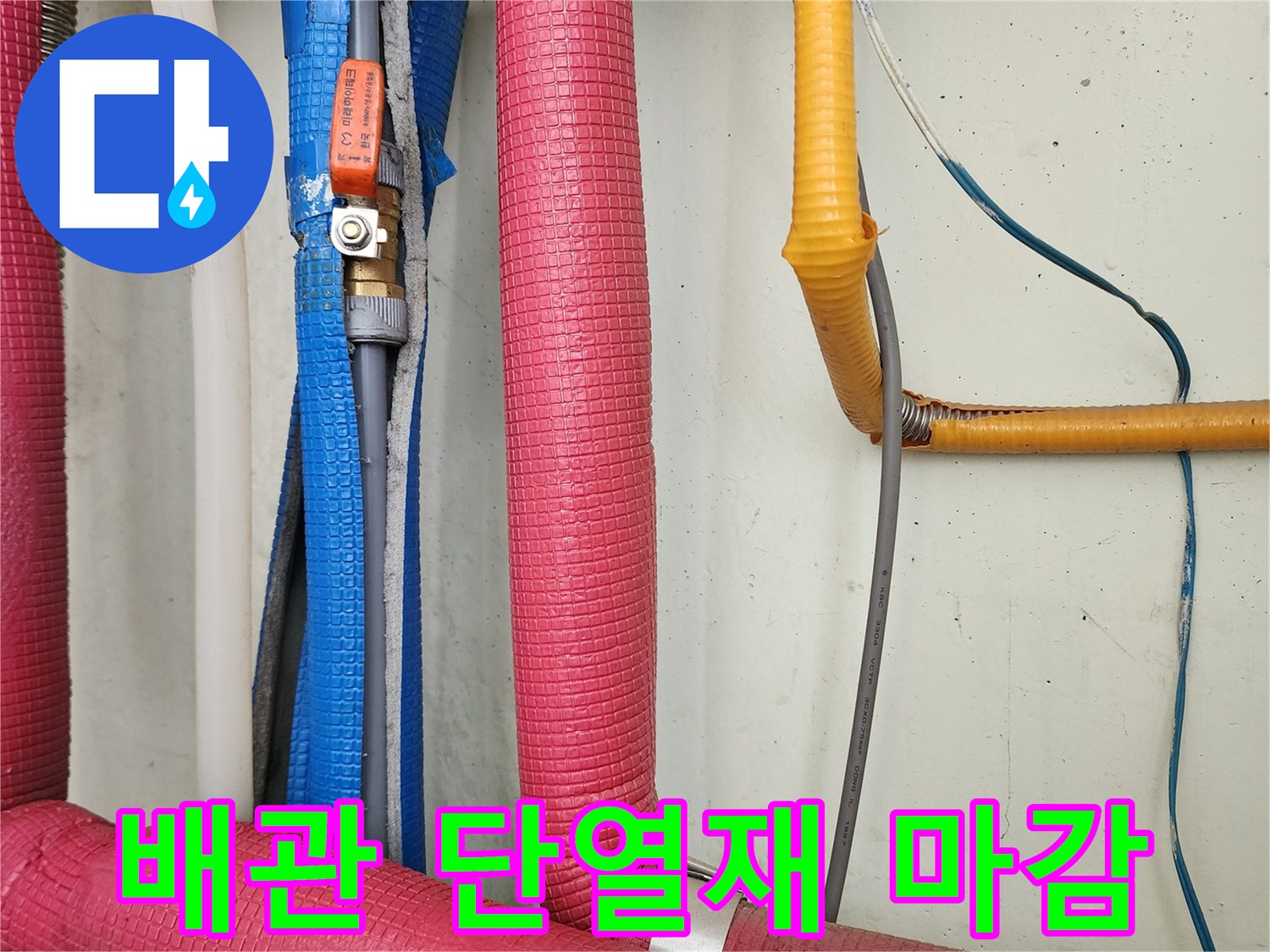 싱크대 하부 배관을 감싸고 있는 붉은색과 노란색 단열재 모습