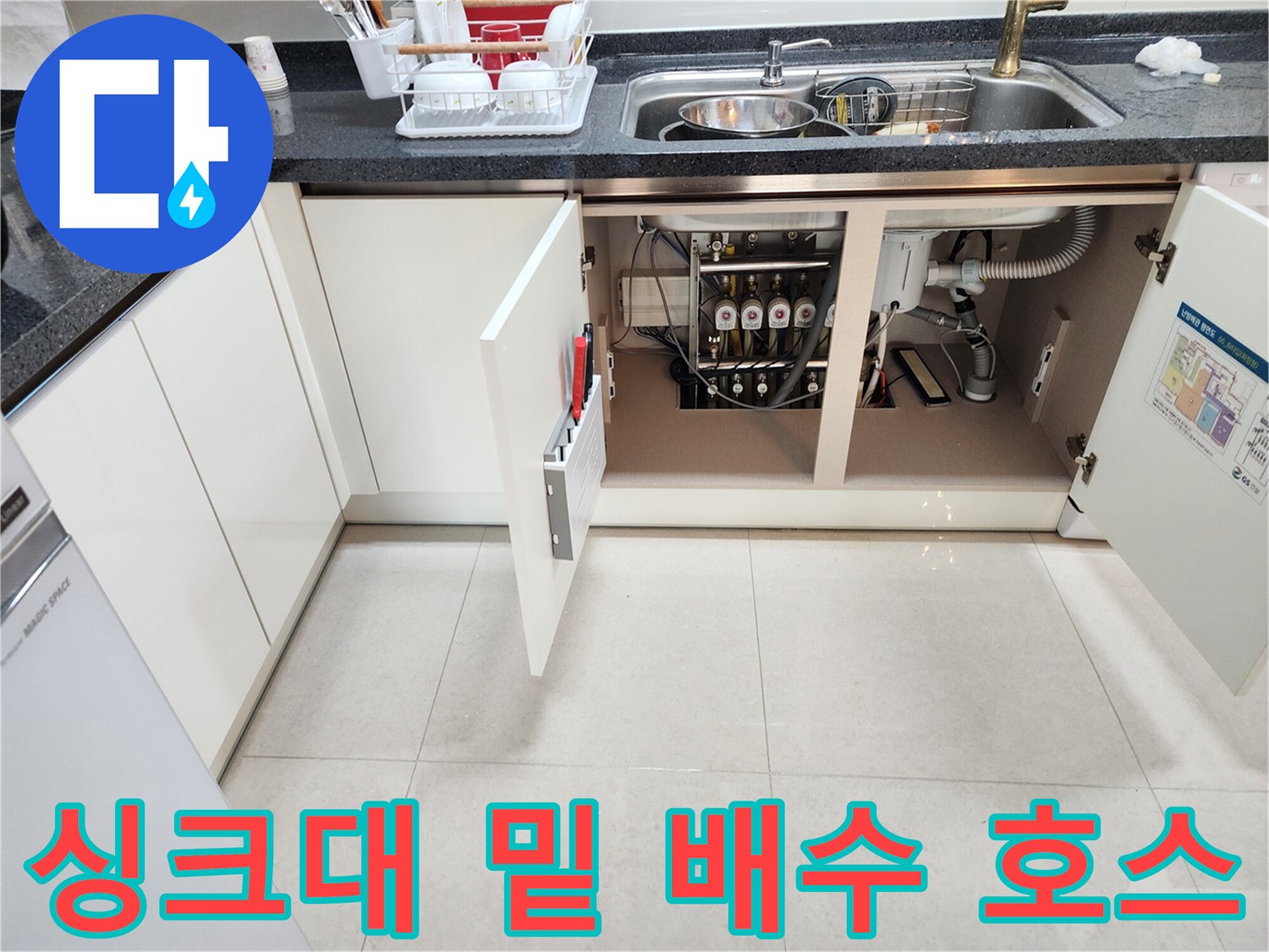 싱크대 하부장 내부의 다양한 배관 및 연결 부속품들