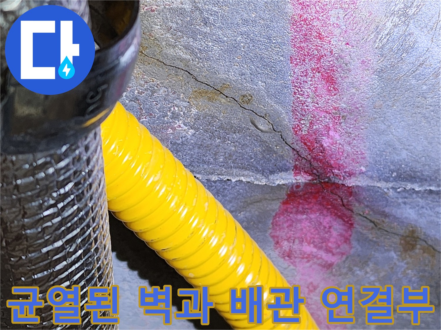 배관 주변 균열-습기가 머문 벽면과 노란색 주름관의 모습