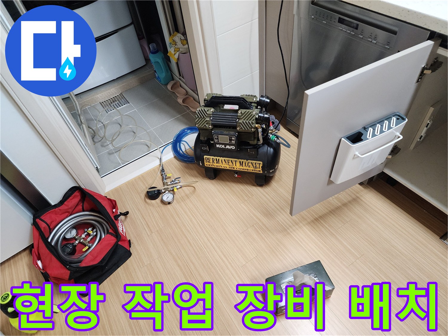 싱크대 옆 공간에 세팅된 배관 세척용 압축기와 공구 가방입니다.