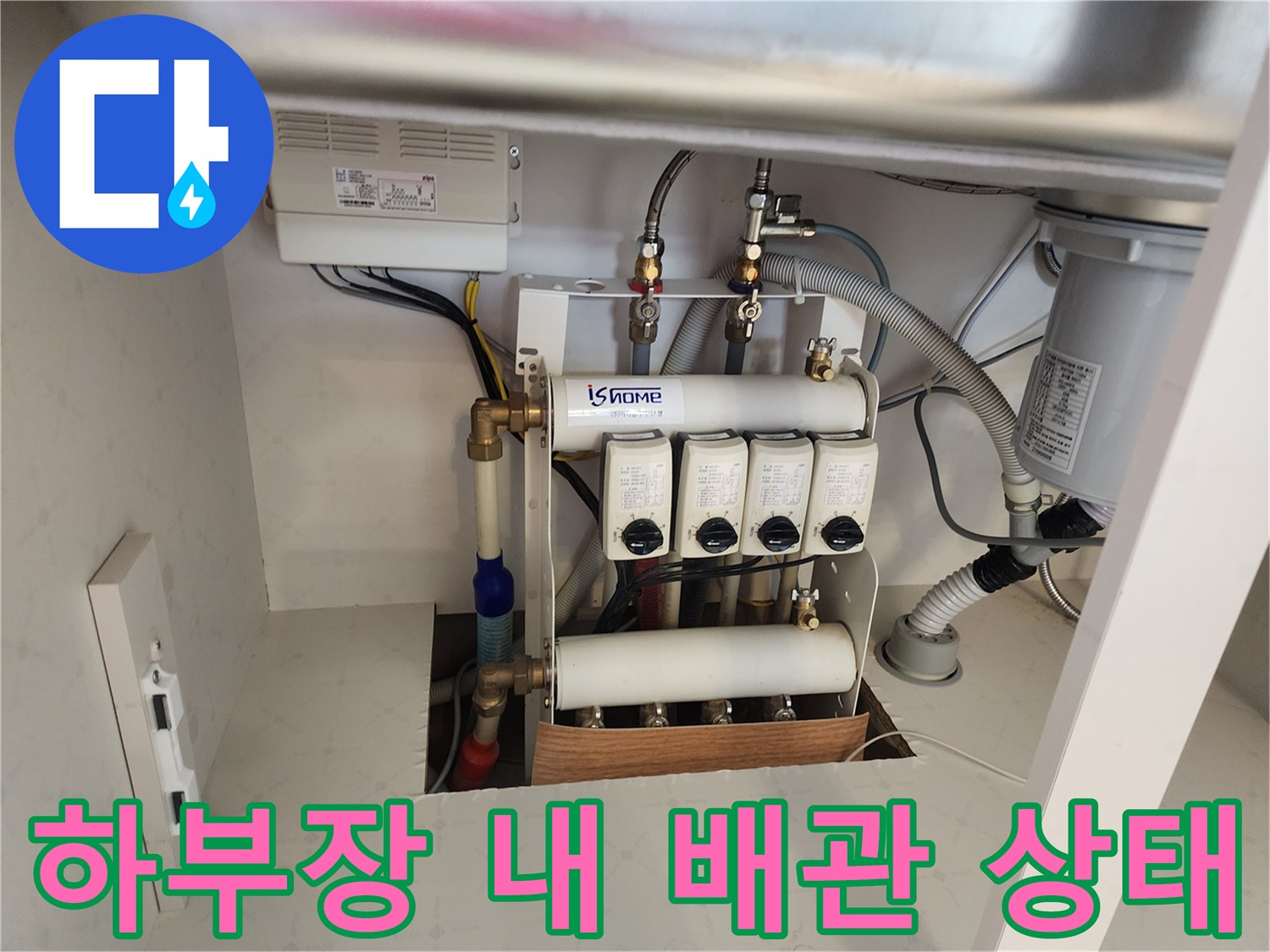 싱크대 하부장의 분배기와 연결된 급수 및 배수 라인의 모습입니다.