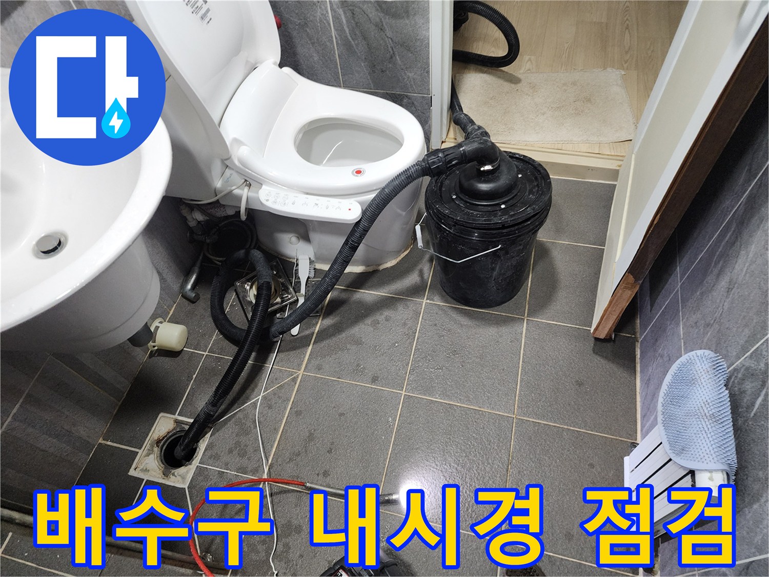 변기 옆 배수구 하단에 설치된 배관 진단용 내시경 카메라와 호스