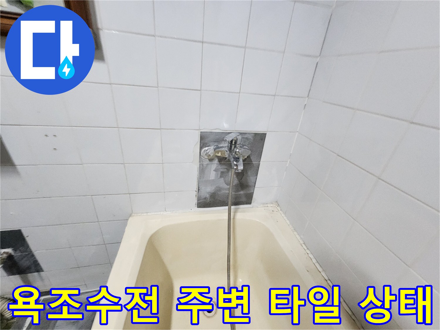 욕조와 벽면 타일이 만나는 수전 연결 부위의 상태를 촬영한 사진입니다.