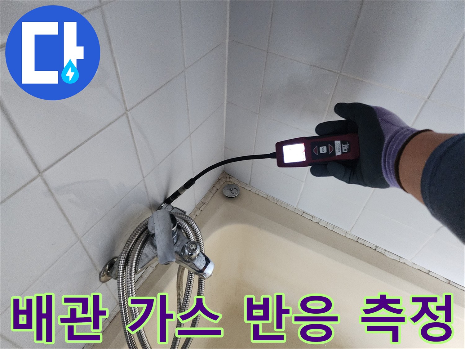 탐지기 센서를 타일 벽면에 대고 배관의 누설 여부를 확인하고 있습니다.
