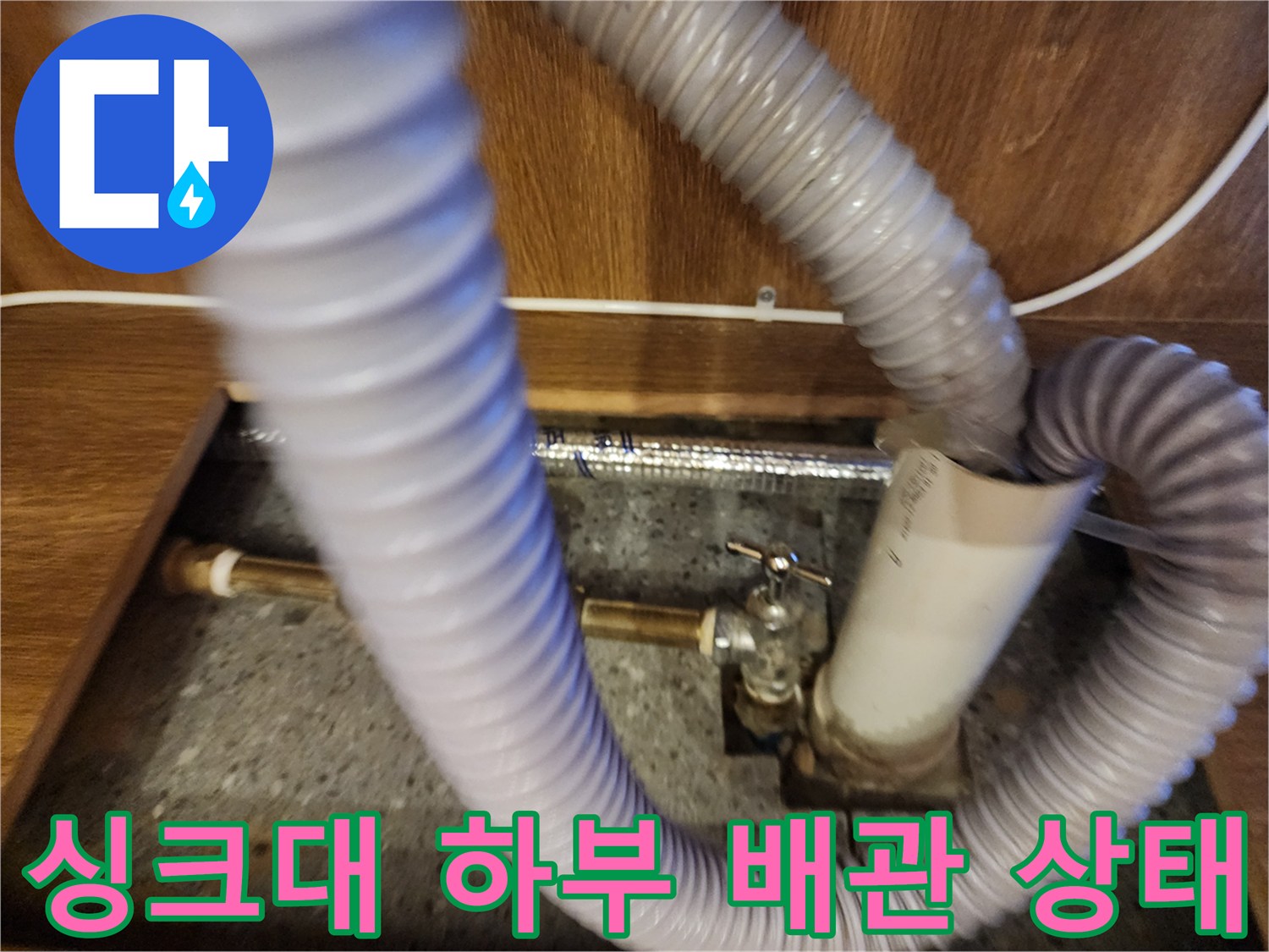 주방 싱크대 내부-온수기 연결 호스와 배관 구조물