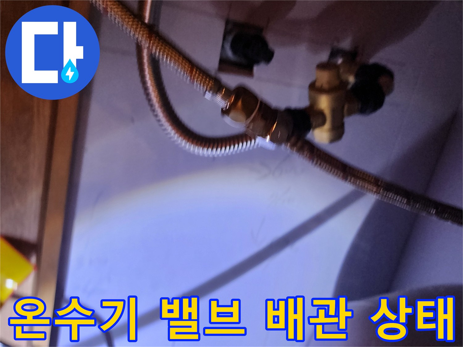 하부장 내부의 전기 온수기와 연결된 수도 부속품 상세 모습