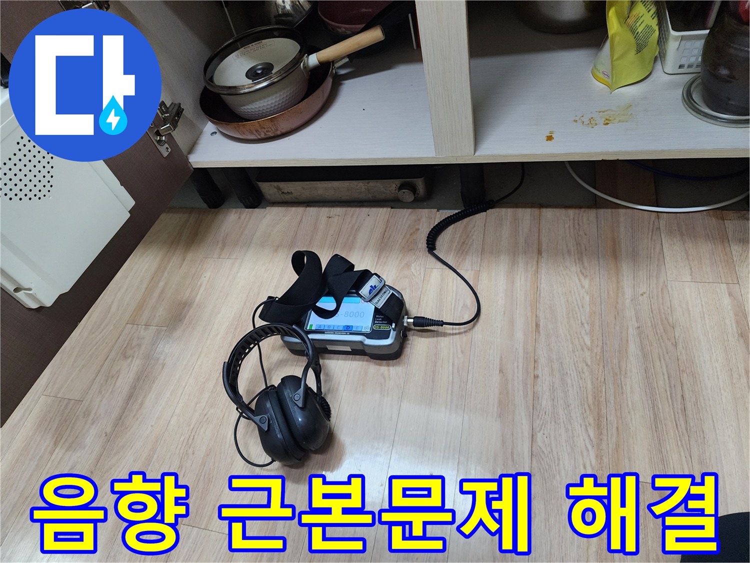 누수의 근본적인 문제를 해결하기 위해-음향 탐지 장비와-헤드폰을 함께 사용하여-정밀하게 검사하는 모습입니다.