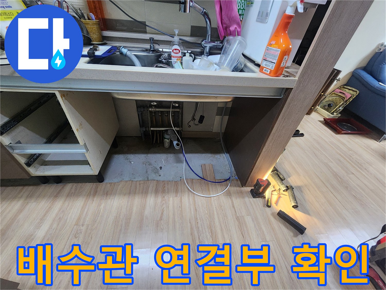 싱크대-아래-배수관과-메인-하수관의-연결-부위를-집중적으로-점검하며-누수-징후를-찾는-모습