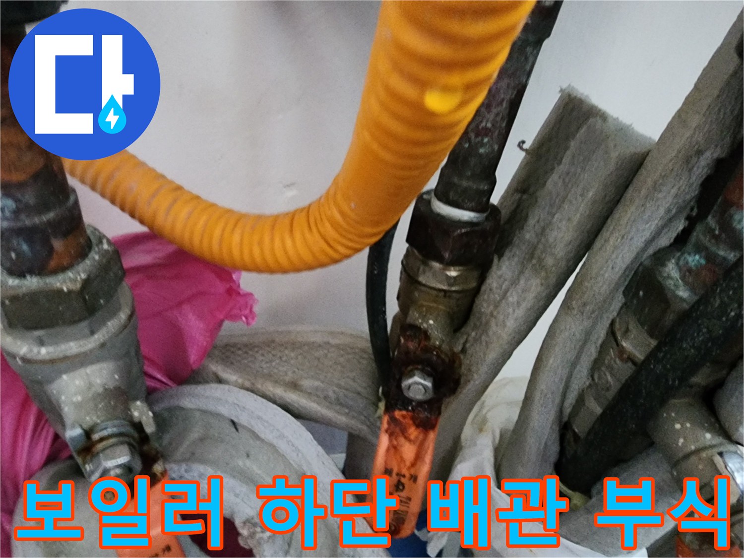 부식된 금속 밸브와 노란색 보온재가 있는 배관 연결구
