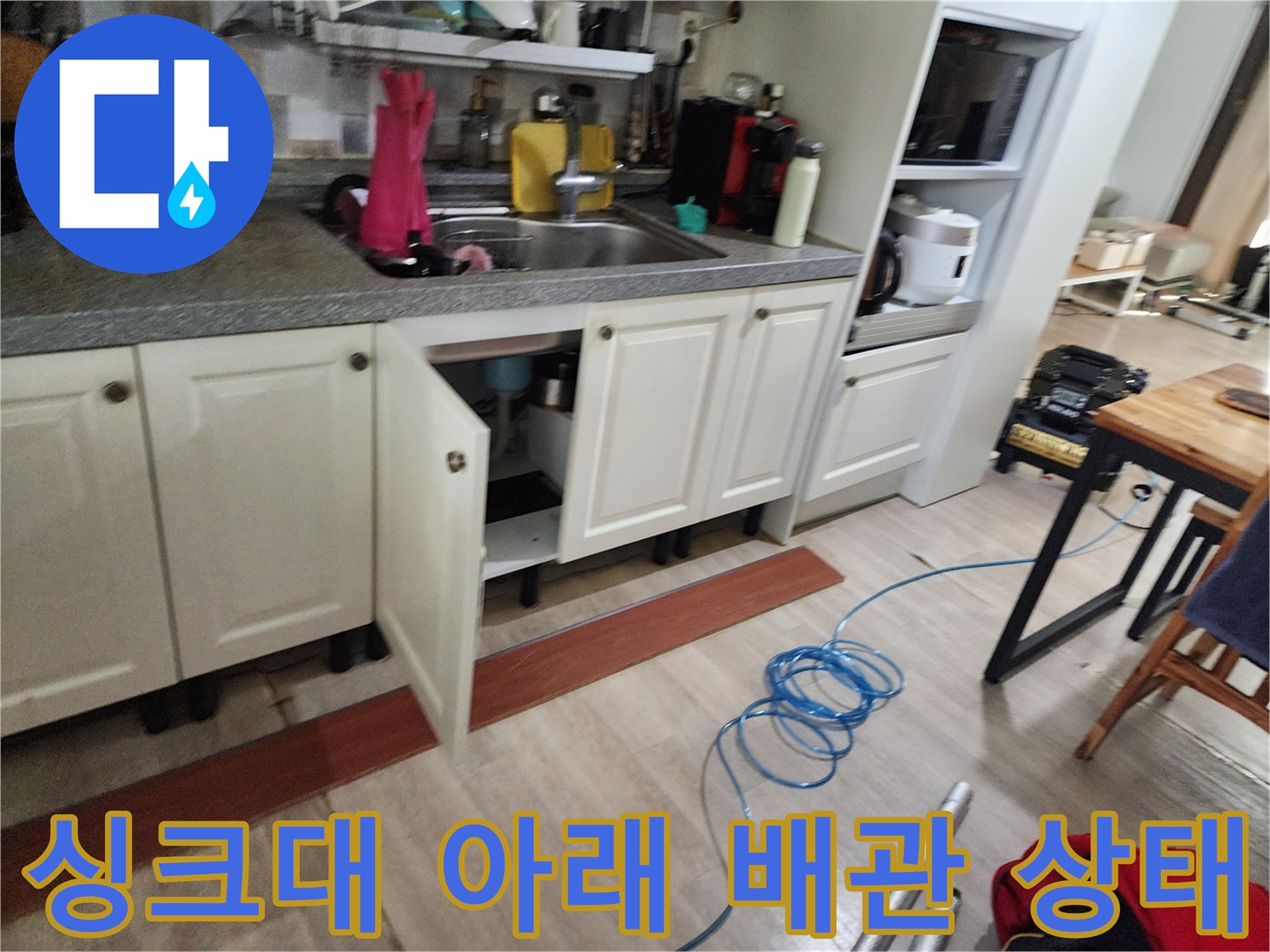 싱크대 하부장 내부에 위치한 각종 배관과 주변 환경을 촬영한 사진