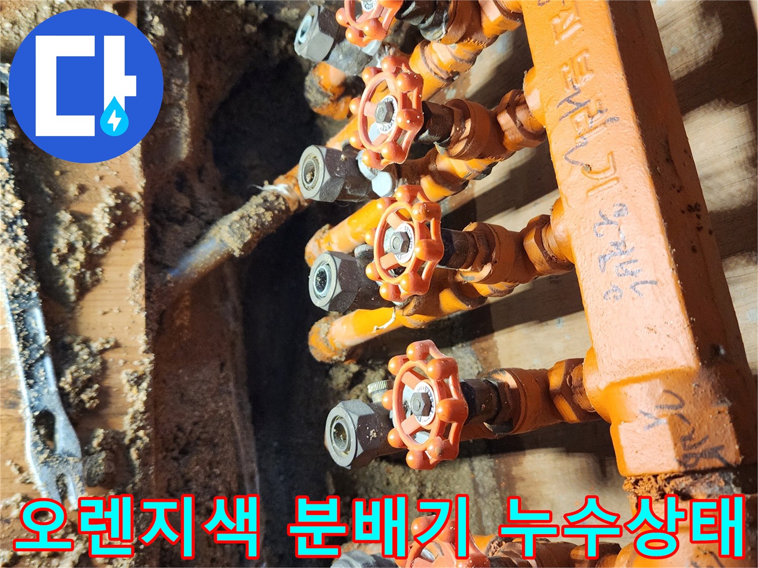 오렌지색 보온재로 감싸진-난방 분배기 밸브 연결부의 누수 현장