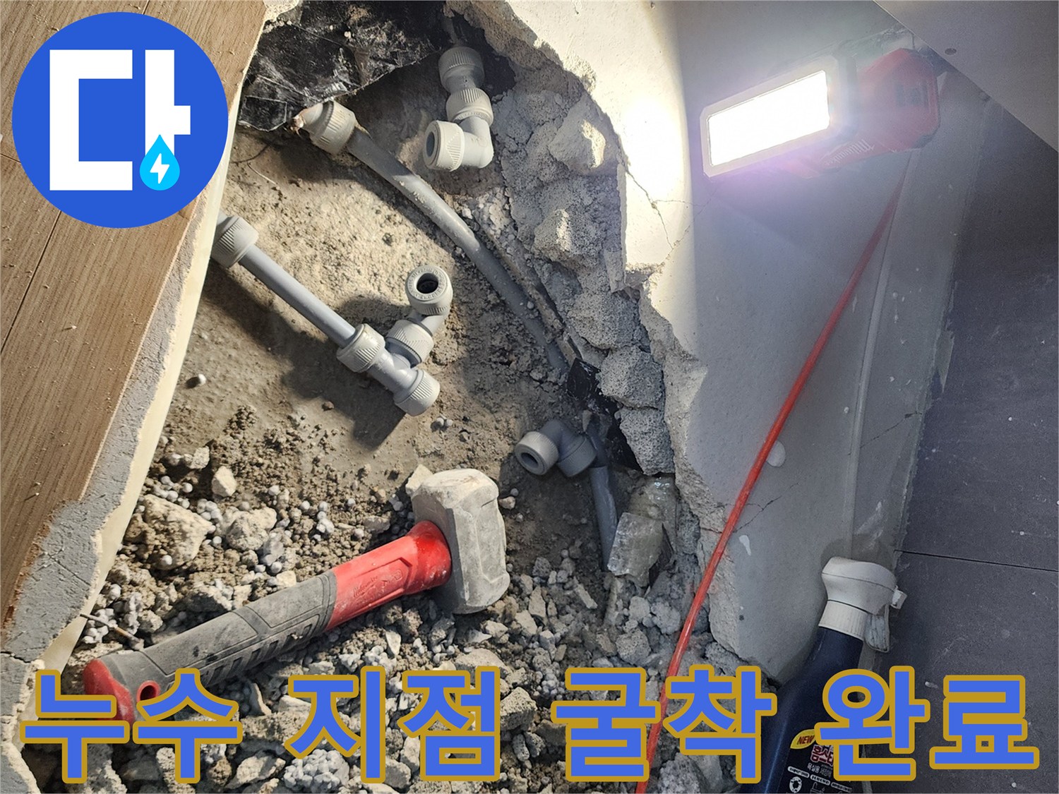파헤쳐진 바닥 속 회색 배관과 누수가 의심되는 연결 부위