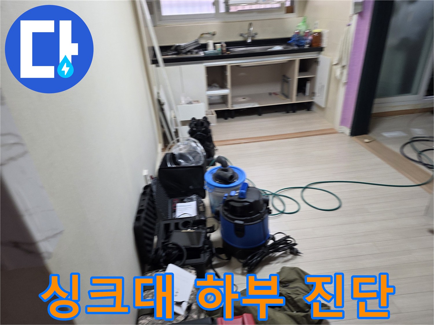 싱크대 아래 누수 지점을 찾기 위해 배치된 탐지 장비와 도구들