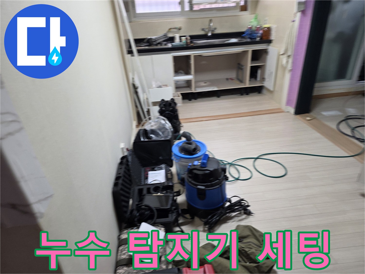 싱크대 하부 공간의 배관 문제를 확인하기 위해 배치된 정밀 측정 기구들