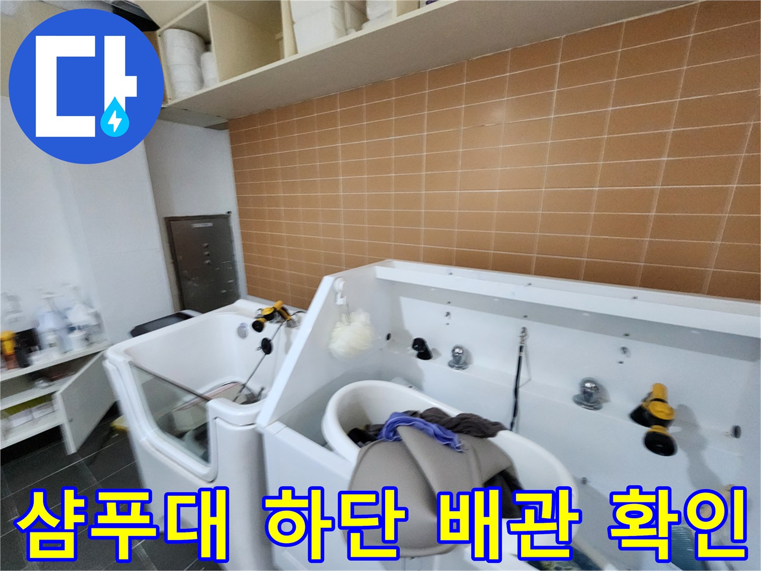 샴푸대 세면대 하단의 배수 부속과 주변 환경 점검 중