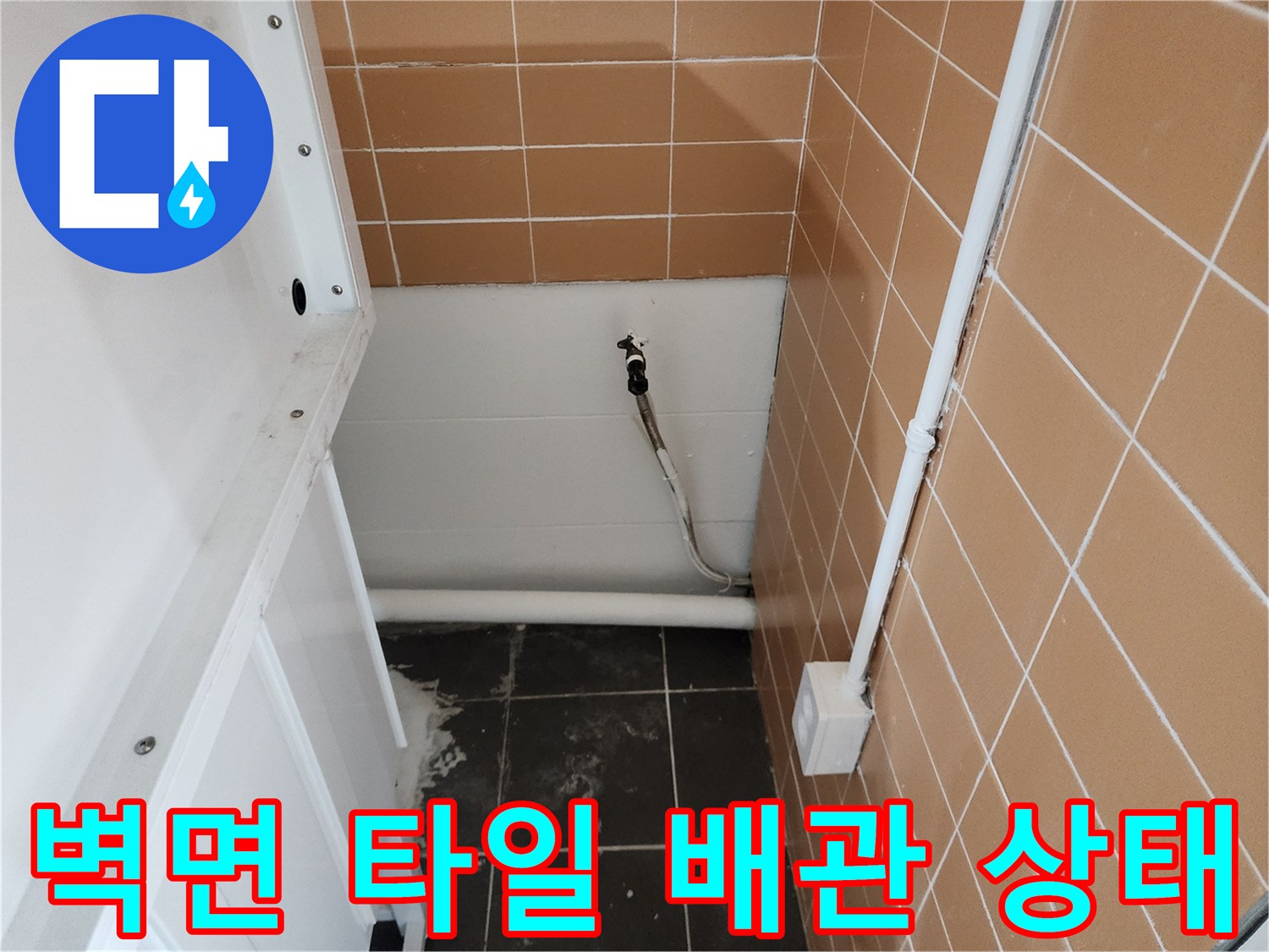샴푸대 아래 벽면 패널과 노출된 급수 배관 모습