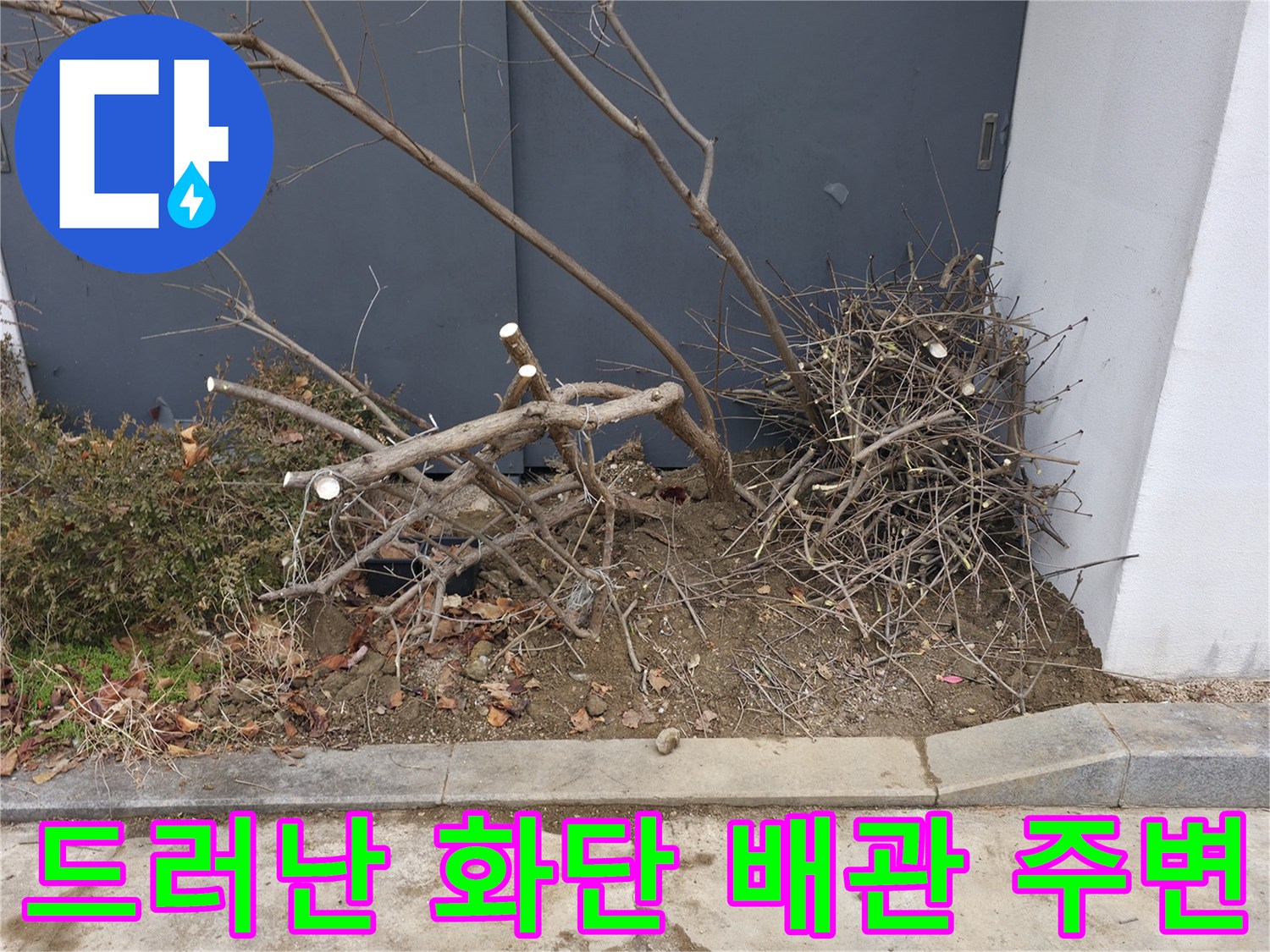 건물 외벽 하단-파헤쳐진 흙과 배관 노출 부위