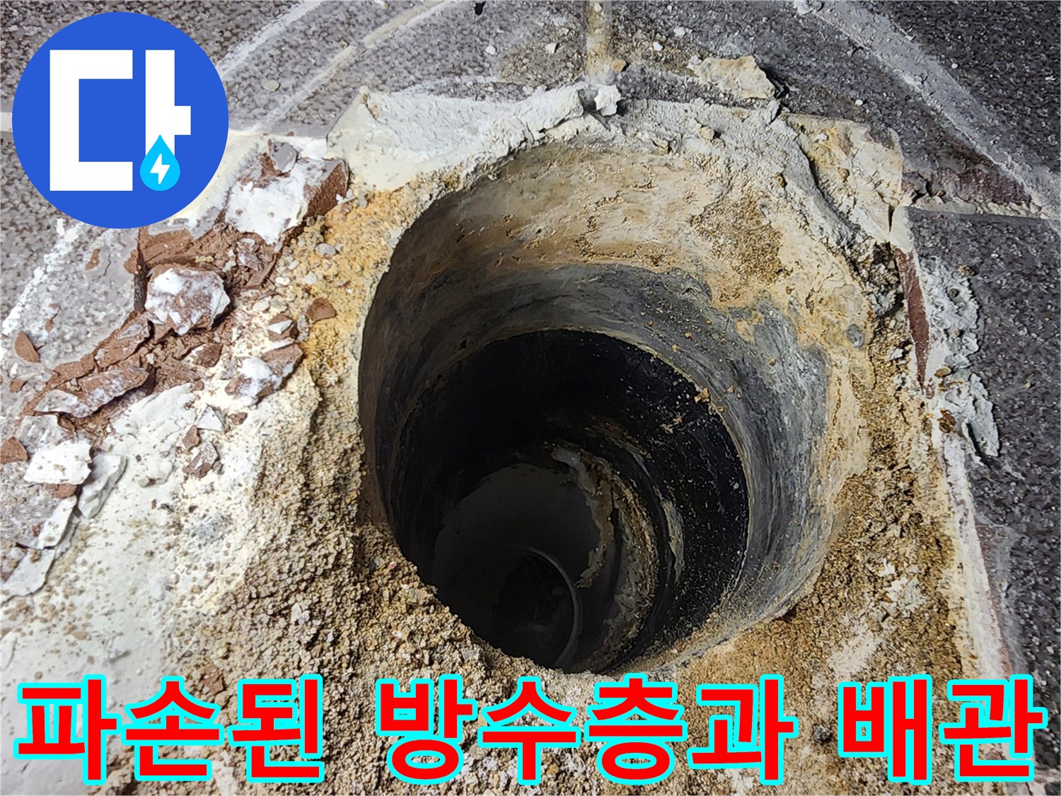 배관 주변의 젖은 모래와 깨진 마감재를 촬영한 사진입니다.