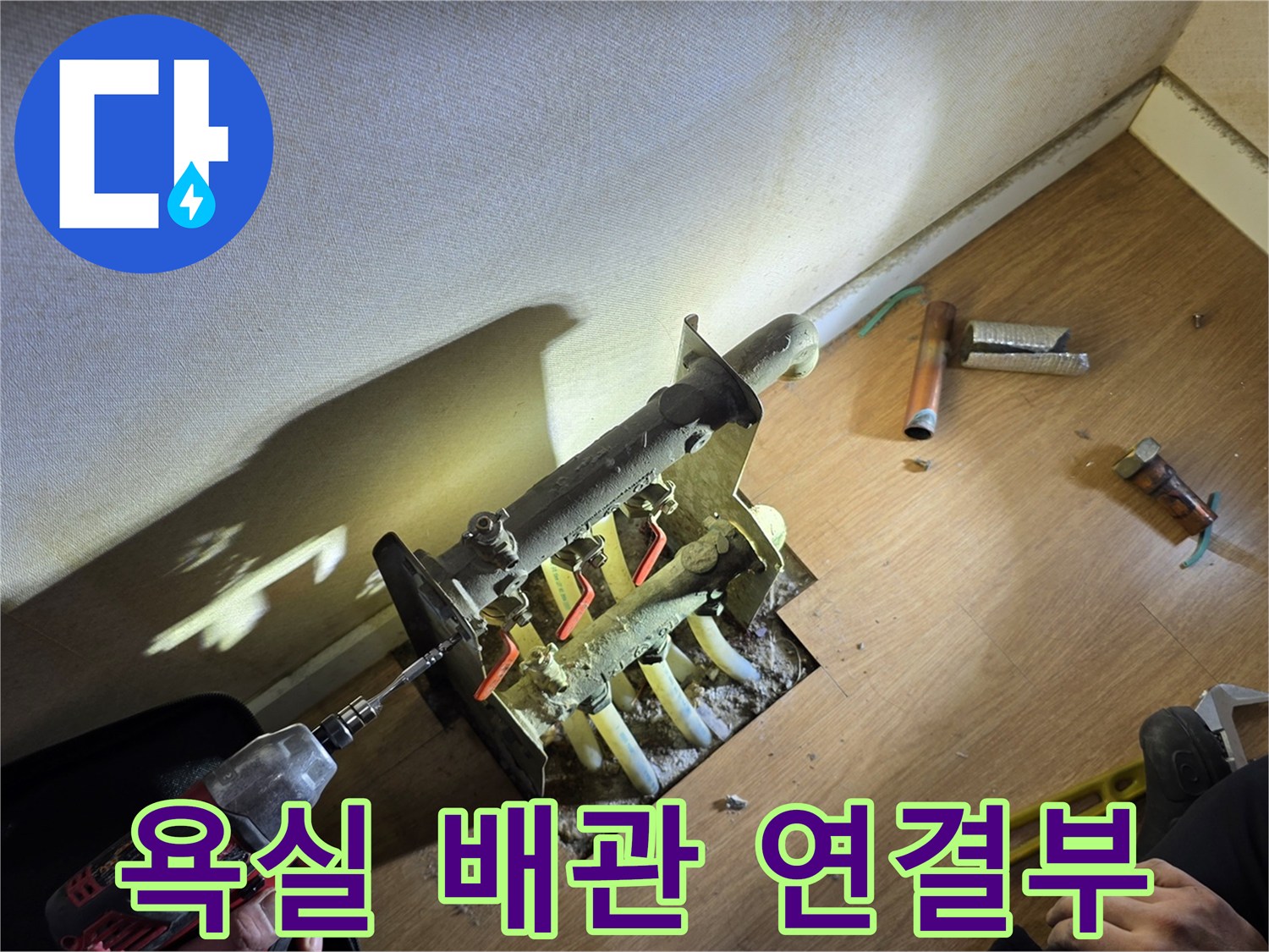 욕실 벽면 내부에 노출된 온수 분배기와 배관 연결 부위 모습