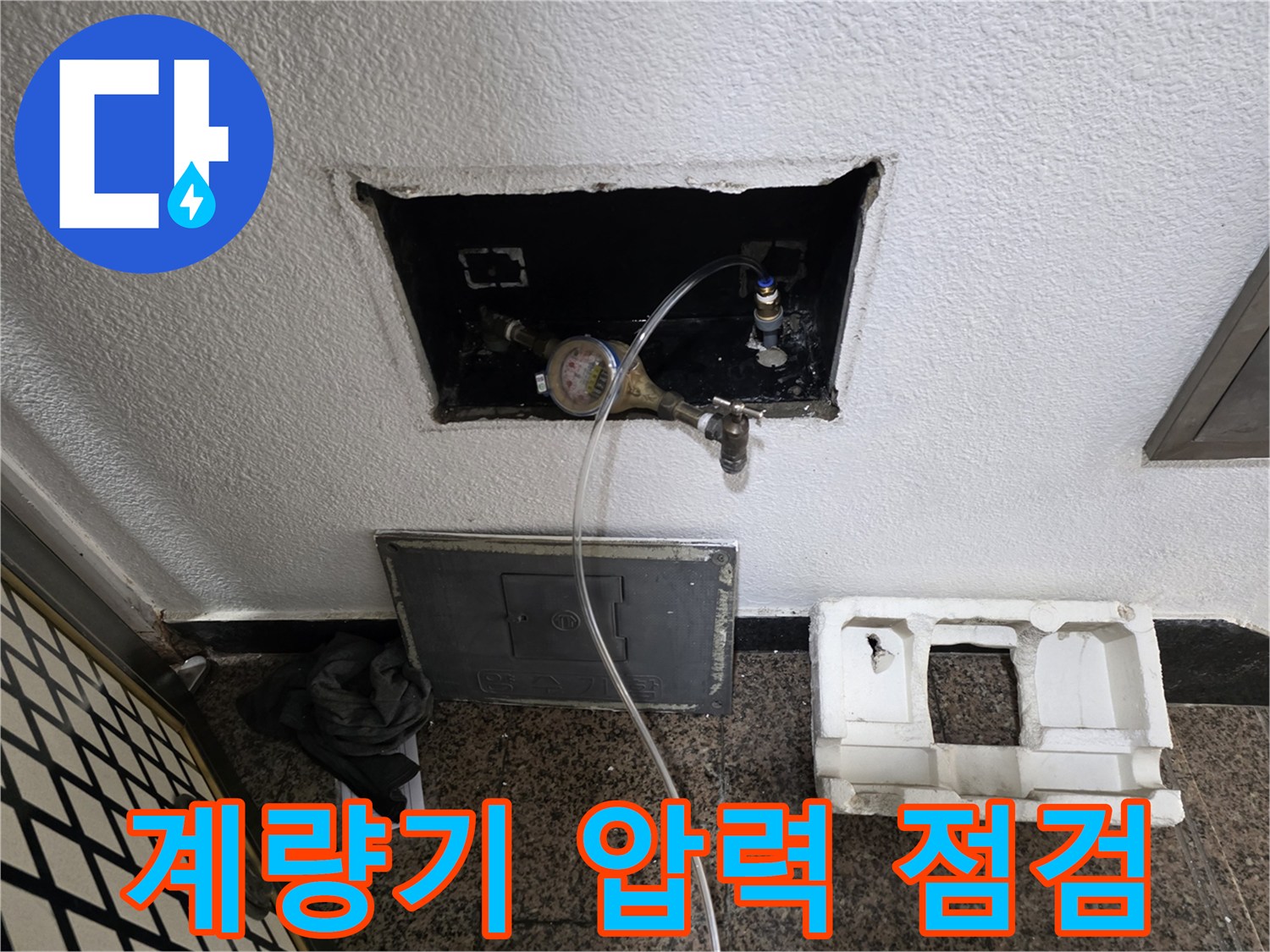 수도 계량기에 압력계를 연결하여 배관의 기밀 상태를 확인하는 모습입니다.