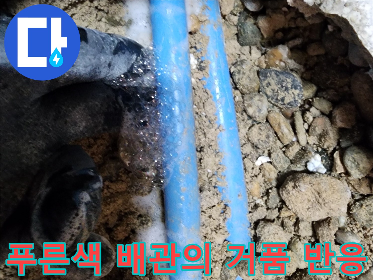 자갈 사이로 드러난 푸른색 배관에 거품이 올라오며 물샘을 알리는 장면