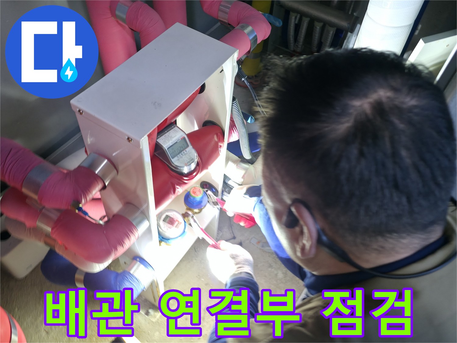 보온재가 씌워진 배관 사이의 연결 부위를 엔지니어가 집중해서 관찰합니다.