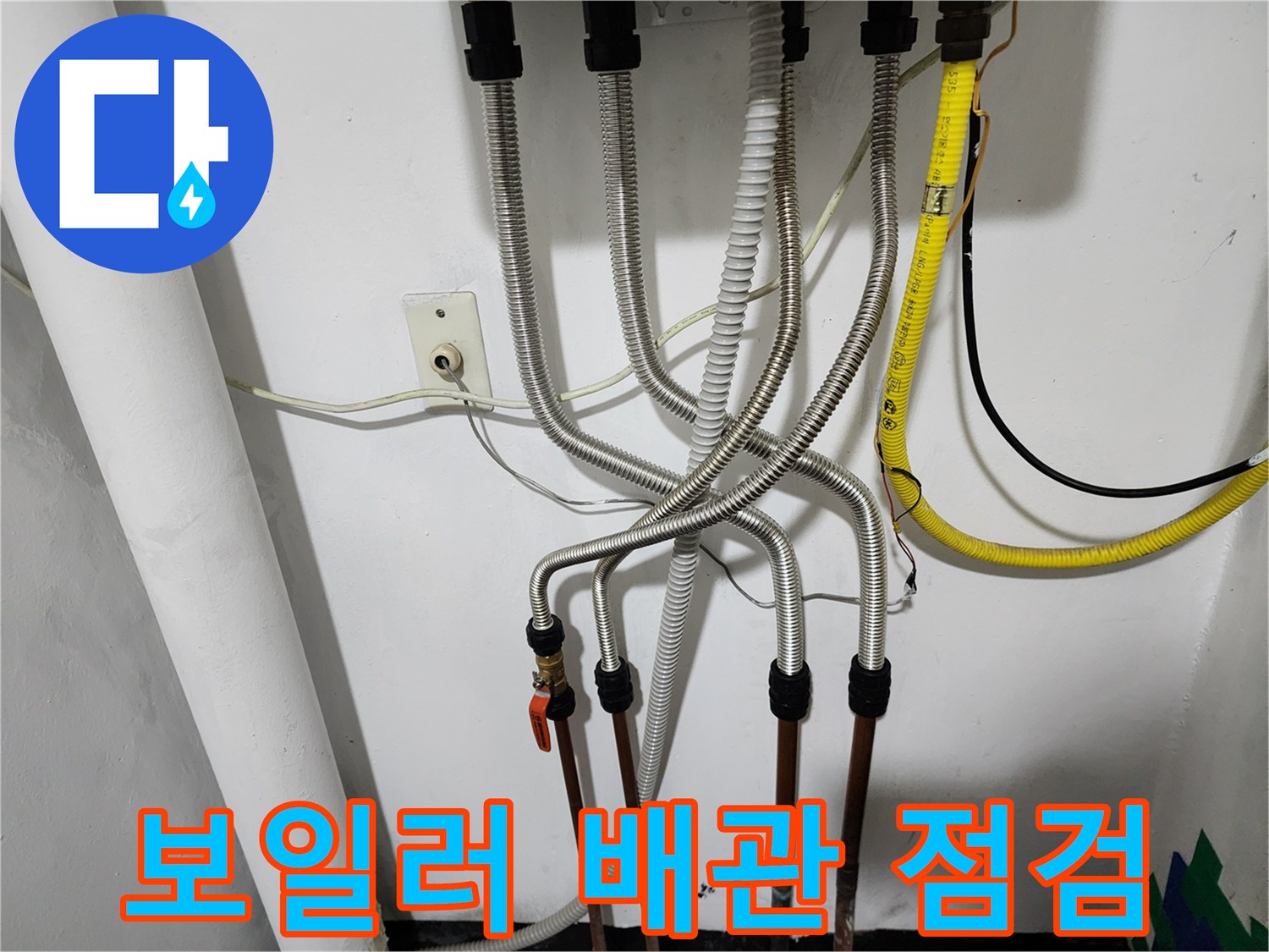 보일러실 하단에 연결된 은색 주름관과 동배관의 상태를 확인하는 모습