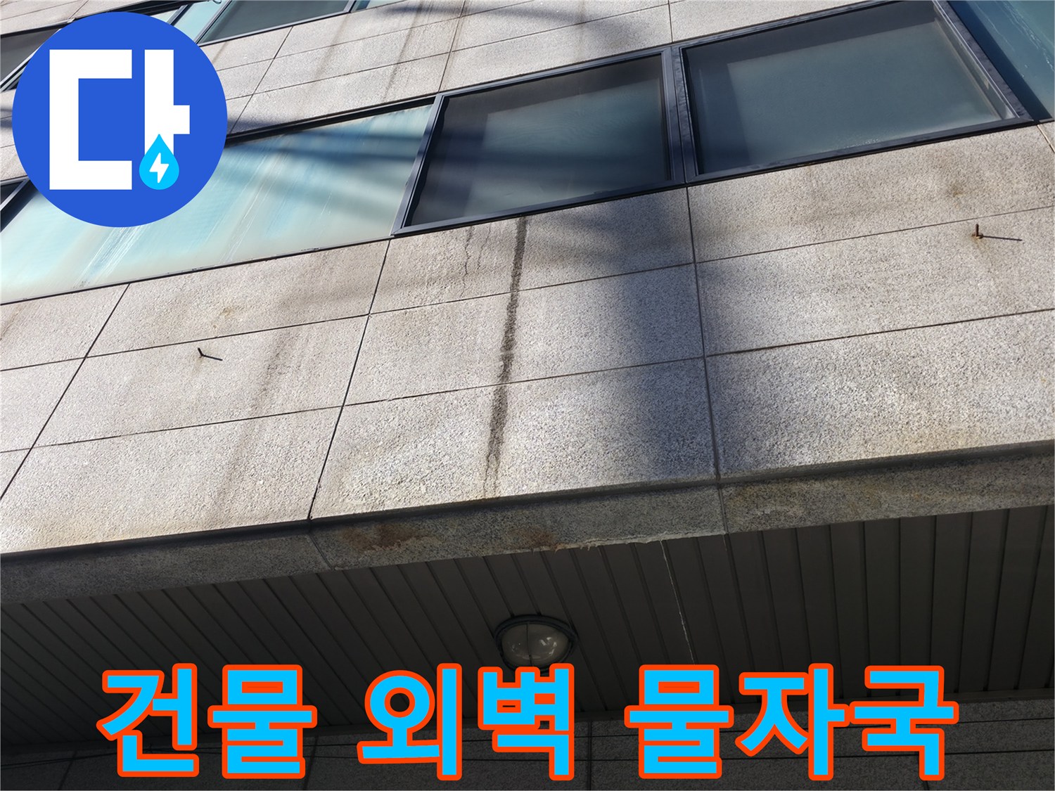 강남구 건물 외벽의 석재 패널에 나타난 짙은 수분 흔적과 변색된 상태입니다.