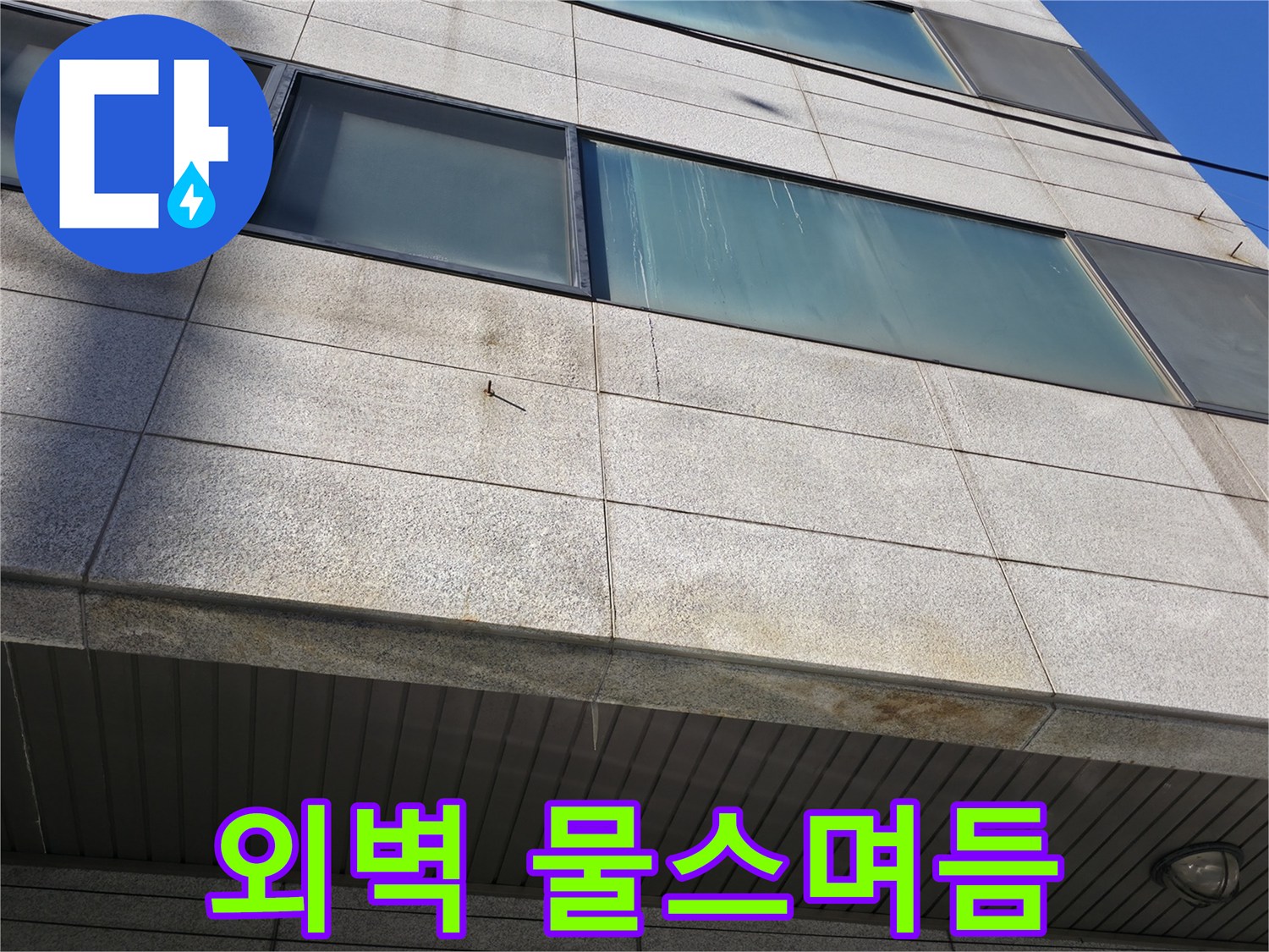 건물 외부 석재 마감 부위의 습기 흔적과 얼룩