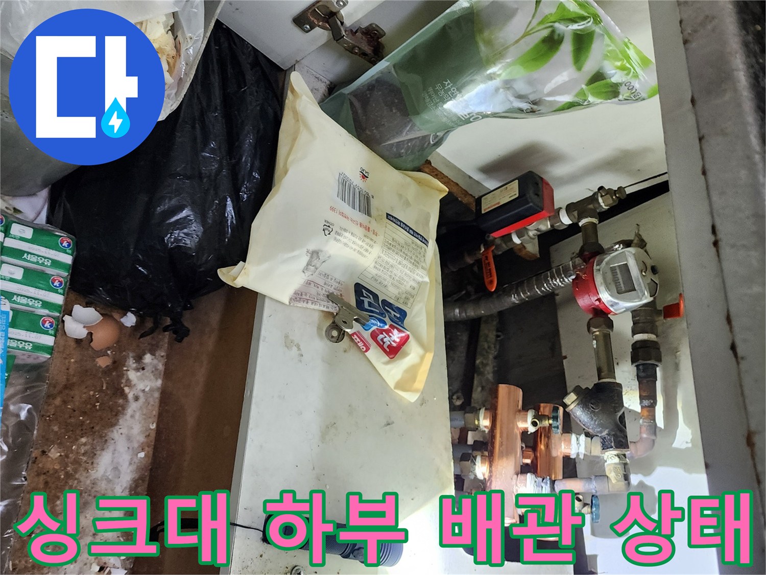 싱크대 하단 배관과 부속품의 연결 상태를 보여주는 사진