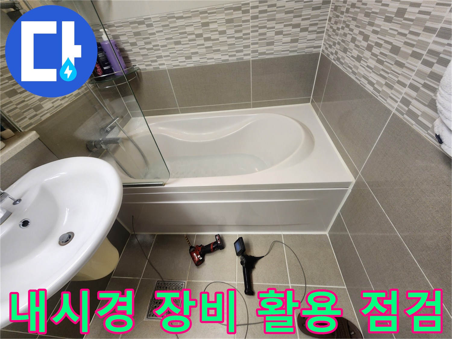 전동드릴과 내시경 카메라를 사용하여 욕조 아래 배관을 검사하는 현장