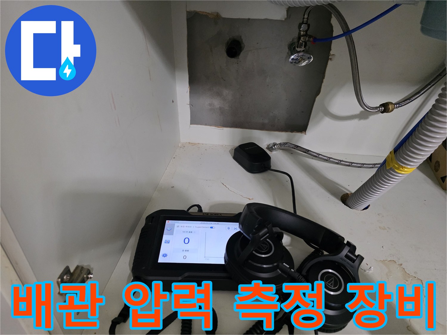 누수 지점을 찾기 위해-디지털 압력 게이지와 헤드셋을 사용 중인 모습