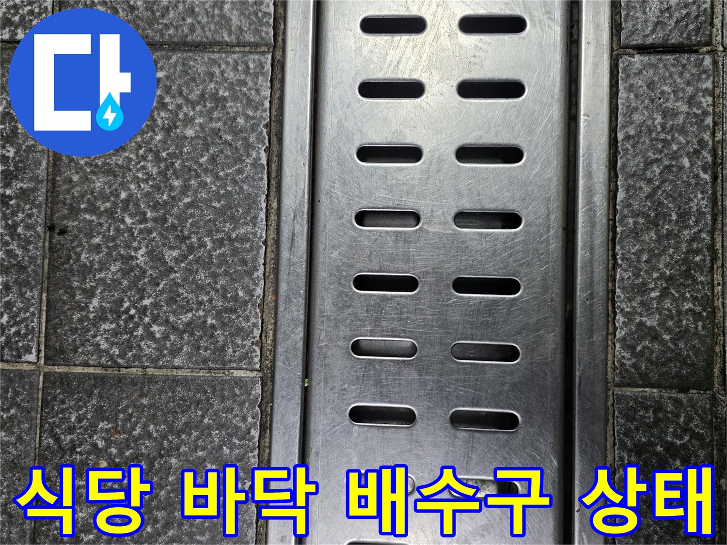 스테인리스 배수구와 파손된 줄눈이 보이는 타일