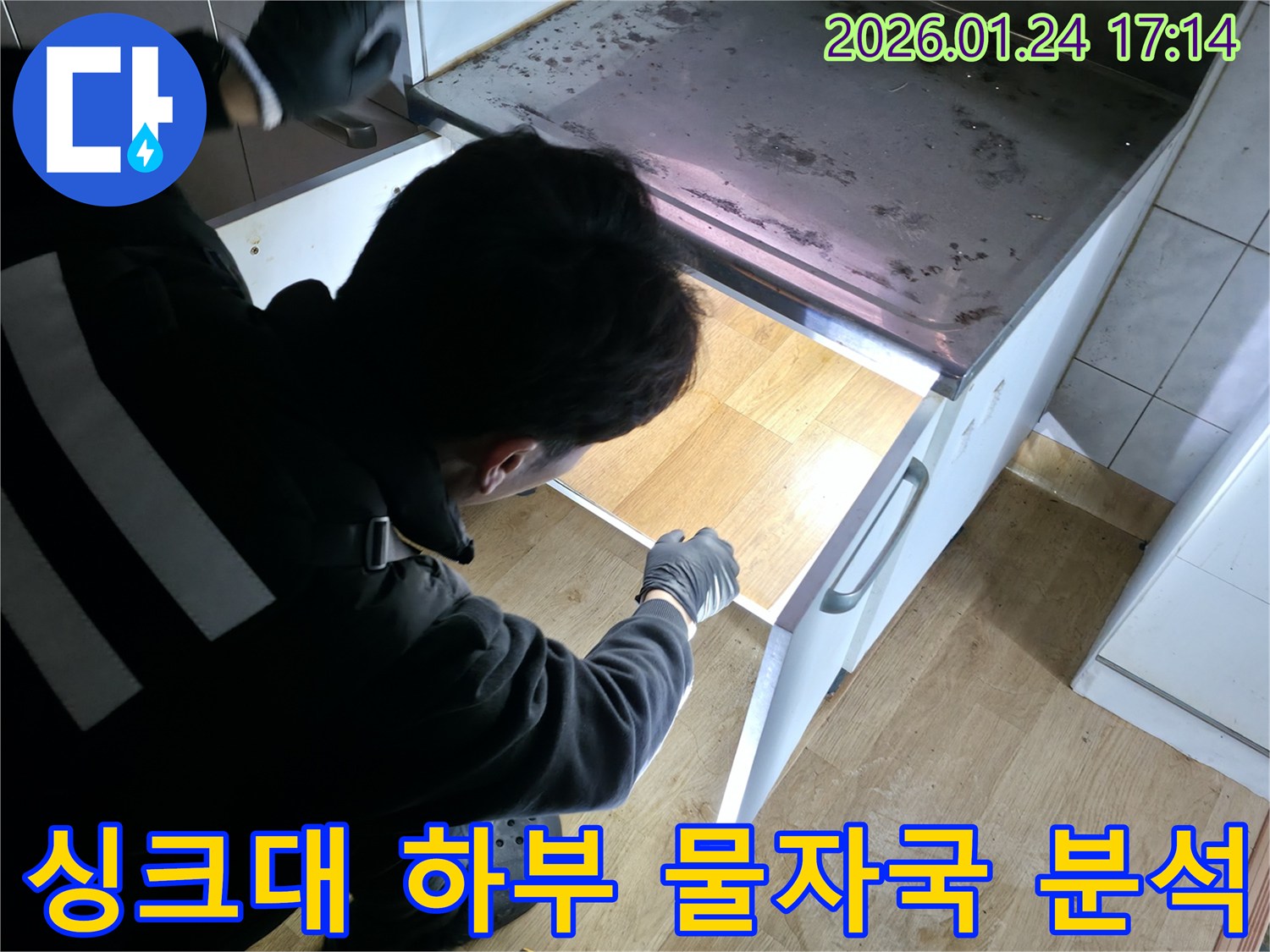 강북구 누수 전문가가 싱크대 하부의 물자국 흔적을 분석하며 누수 경로를 추적하고 있습니다 - 미세한 흔적도 놓치지 않습니다.