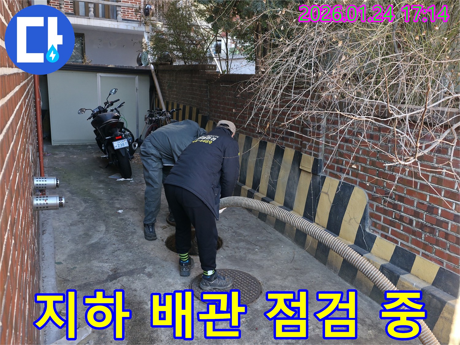 강북구 수유동-지하 배관의 누수 여부를 확인하기 위해-전문가가 맨홀을 통해-점검 작업을 진행하는 모습