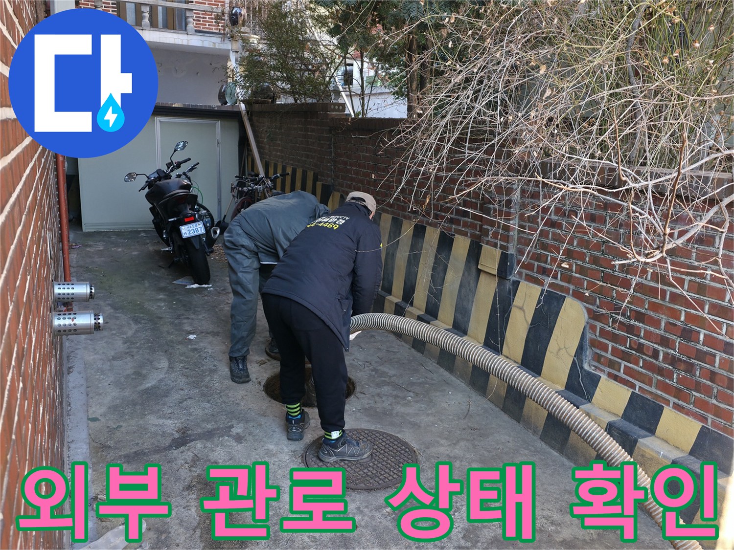 맨홀 부근 배관의 막힘 현상을 조사하는 기술자