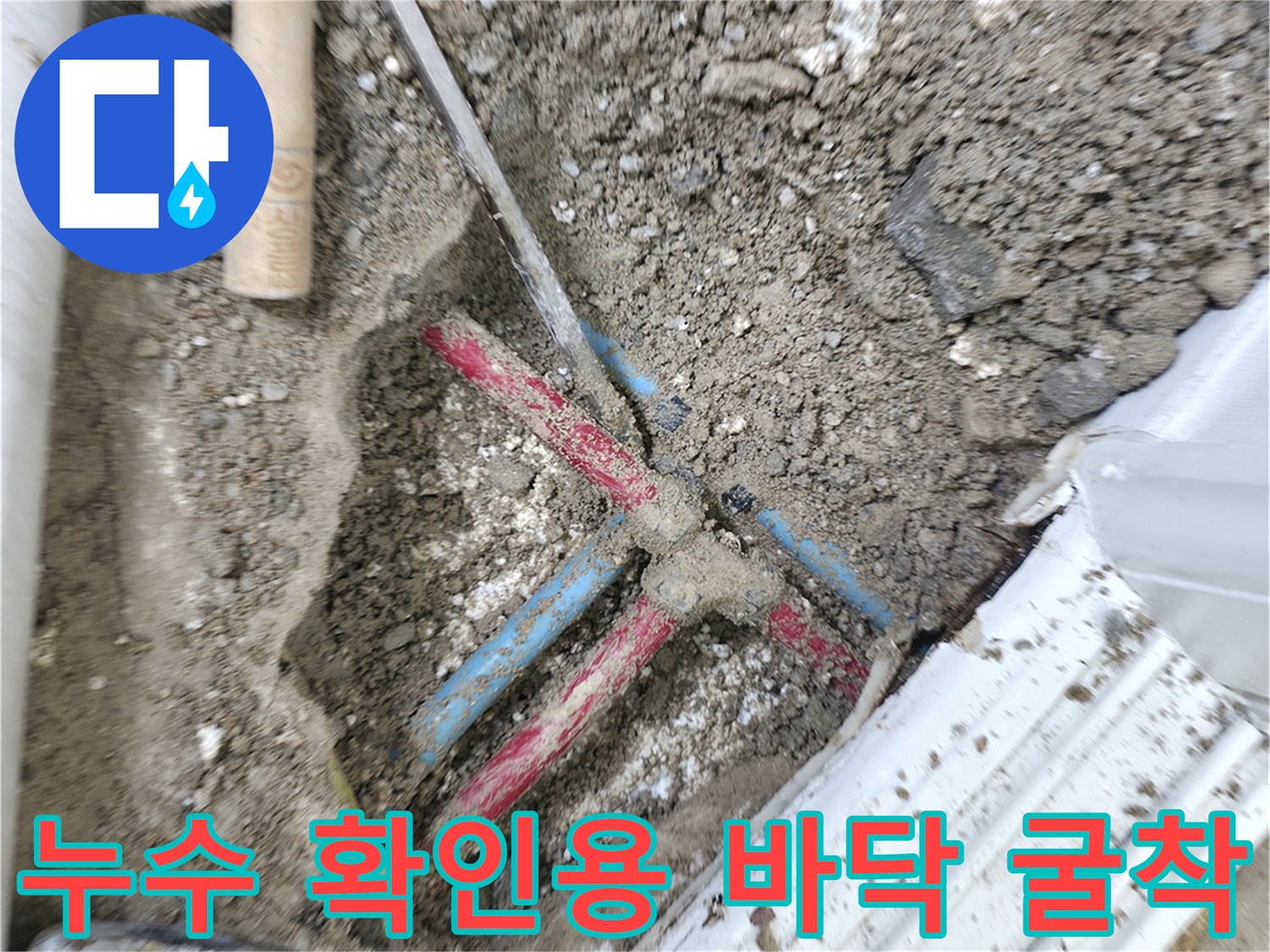 공사 중 드러난 흙과 파란색 빨간색 수도 배관 부위