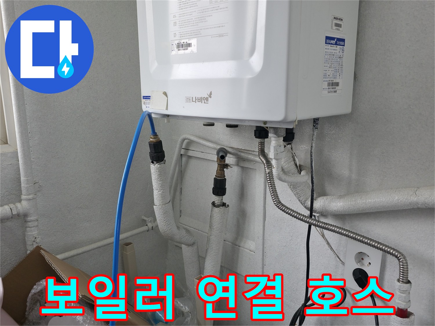 파란색 호스와 흰색 배관이 연결된 보일러실 내부 모습입니다.