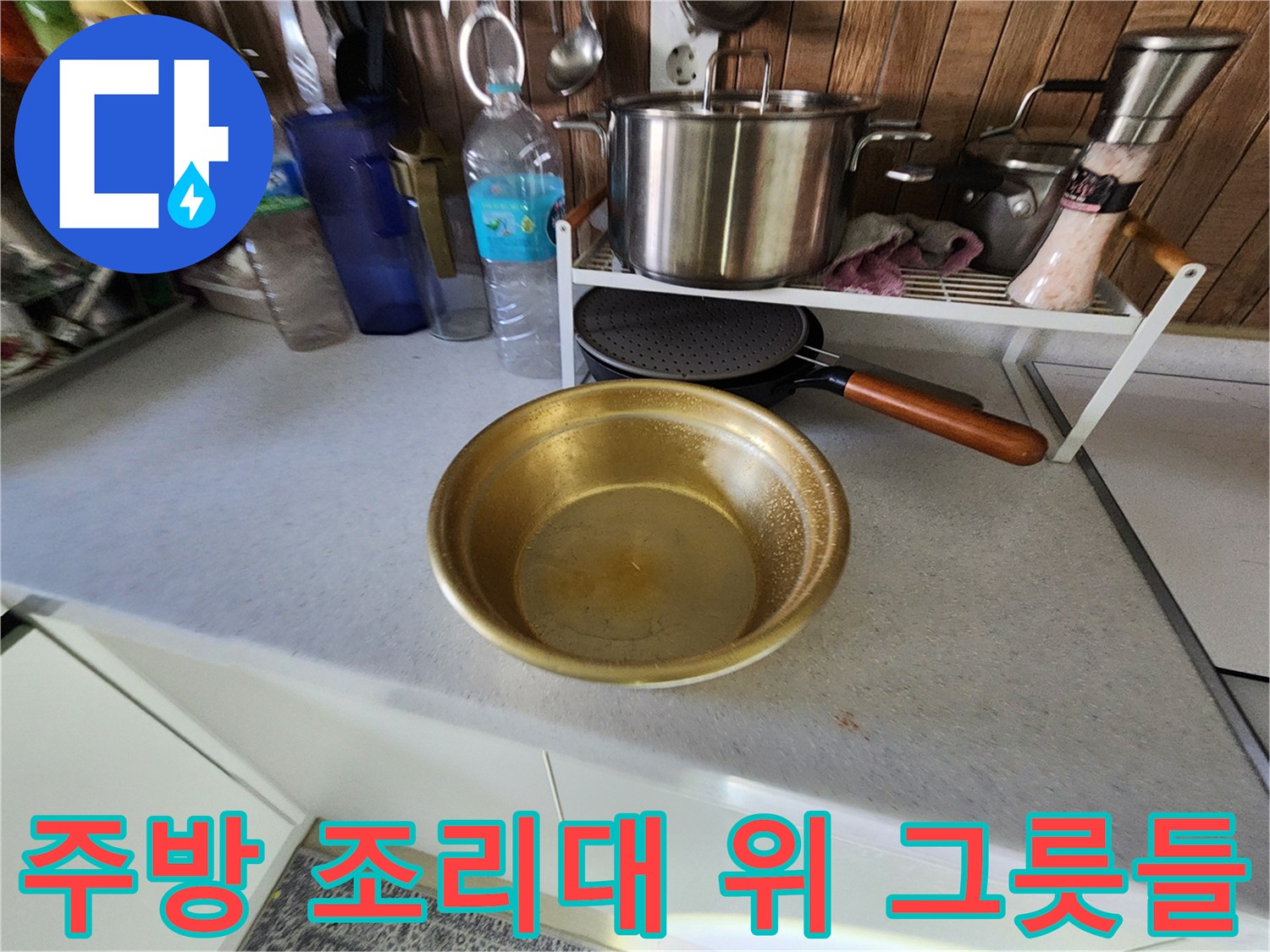 싱크대 상판에 놓여 있는 주방용품과 냄비 사진