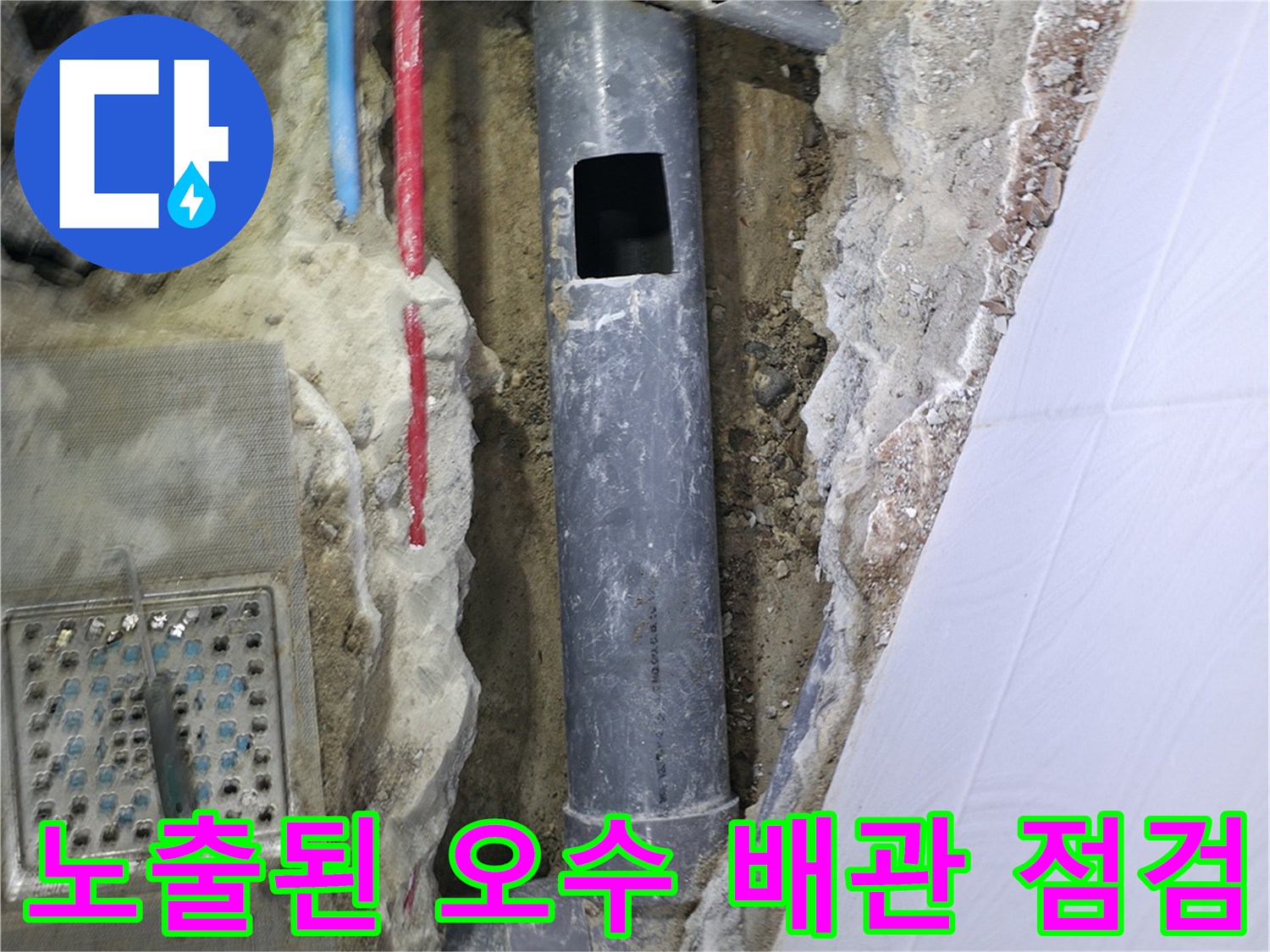 굴착 후 노출된 회색 톤의 오수 배관과 주변 마감재 상태